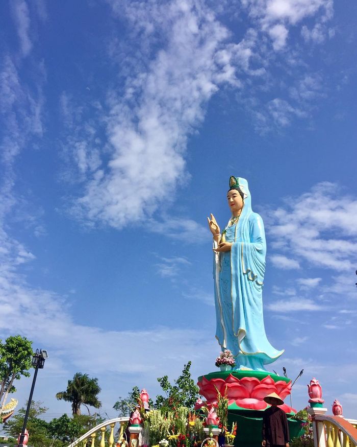 Tượng Phật Bà Quan Âm đứng uy nghi trên đài sen hướng biển Đông lộng gió, ánh hoàng hôn vàng rực